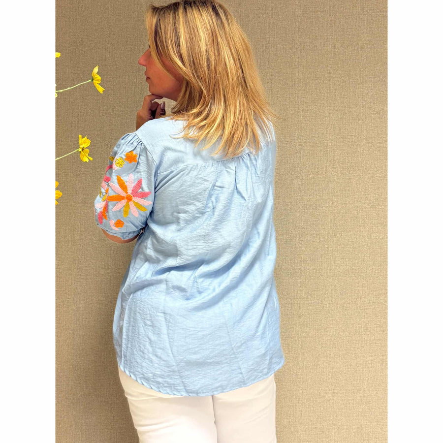 Lichtblauwe bloemenblouse voor dames, stijlvol en elegant.